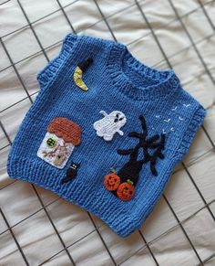 a blue knitted sweater with halloween decorations on it