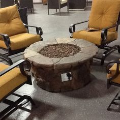 a fire pit surrounded by chairs and tables in a room with tile flooring on the floor