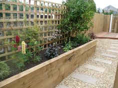 an outdoor garden with wooden fence and plants