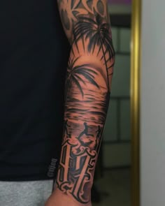 a man's arm with a palm tree and an anchor tattoo on the forearm