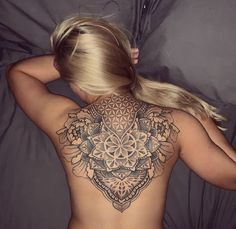 the back of a woman's body with tattoos on her upper and lower half