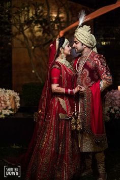 Photo of Traditional bride and groom in maroon outfits Poses Romantic, Groom Pose, Indian Wedding Poses, Bride Photos Poses, Groom Photoshoot