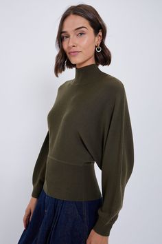 An elevated top in this season's standout color!Crafted from a soft merino wool, the Sergeant Green Karoline Sweater offers a blousey silhouette with mock neck collar and dolman sleeves. Completed with a flattering wide ribbed hem frame, pair with your favorite jeans and boots for an everyday chic look or dress it up with a skirt and heels for the date night ‘fit.Our Favorite Details: Mock neck Dolman sleeves Wide ribbed hem Relaxed fit Material: 100% Merino WoolCare: Dry clean onlyAbout the Bra Fall Wool Top With Funnel Neck, Modern Funnel Neck Top For Fall, Modern Mock Neck Top For Fall, Mock Neck Top For Work, Wool Funnel Neck Tops For Fall, Modern Turtleneck For Fall, Modern Mock Neck Turtleneck Top For Fall, Fall Mock Neck Top For Workwear, Fine Knit Mock Neck Top For Fall