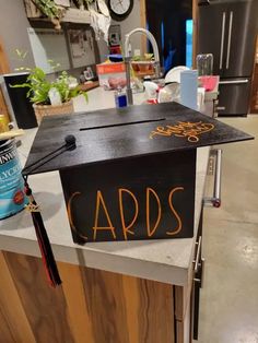 a graduation cap with the words cards on it sitting on top of a kitchen counter