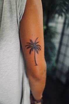 a woman with a palm tree tattoo on her arm