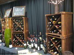 several wooden wine racks are lined up on a table with bottles and lights in front of them