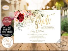 an elegant floral wedding card with gold foil lettering and roses on the front, is sitting on top of a wooden table