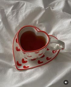 a heart shaped tea cup on a white sheet