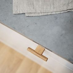 a wooden door handle in front of a wall