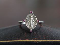 *Saint Michael's jewelry is all hand-made. Please note that each piece of jewelry is specially hand-made when you order and will take production time described below before being despatched.* Caeles Miraculous Medal Ruby Ring is a new series of our Maria Miraculous Medal (マリア リング) line, one of our most popular products using the symbolic Miraculous Medal that was created in response to a request from the Blessed Virgin Mary. The Miraculous Medal is originated from Saint Catherine Labouré followi Mary Mother Of God, Rubin Ring, Saint Catherine, The Blessed Virgin Mary, Mother Of God, Saint Michael, Blessed Virgin, Popular Products, Detailed Ring