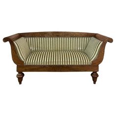 an old wooden couch with green and white striped fabric on the back, against a white background