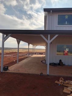 a large white building sitting on top of a dirt field