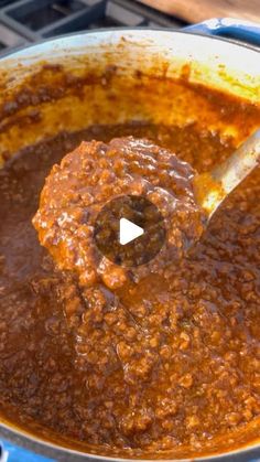 the sauce is being stirred with a ladle in a pot on the stove top