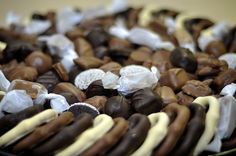 there are many different types of chocolates in the bowl on the table, including pretzels and marshmallows