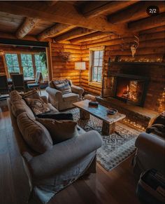 a living room filled with furniture and a fire place in the middle of a wooden wall