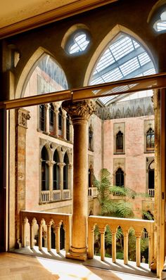 the sun shines through two arched windows into an old building with columns and arches