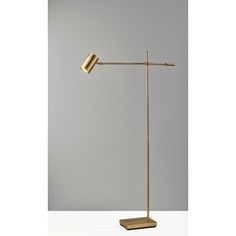 a gold floor lamp with a white background