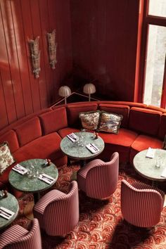 a corner seating area with round tables and chairs