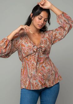 Paisley print Relaxed fit Long voluminous sleeve Elastic wrist cuff Plunging v-neckline Button front Tie front detail Half elastic waist in back Bohemian top Boho Long Sleeve Top, Bohemian Sweater, Volume Sleeves, Classic Blouse, Pretty Orange, Red Long Sleeve Tops, Floral Trousers, Black Playsuit, Classic Blouses