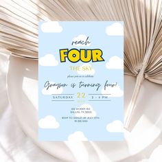 a blue and yellow four birthday party card on a plate next to an open book