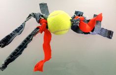 a tennis ball hanging from the side of a racket with ribbons attached to it