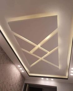 the ceiling in this room is decorated with white and gold geometric designs, along with recessed lighting