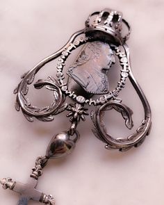 During the Georgian era, when new sources of silver were found in silver-rich South America, the production of silver jewelry flourished. Silver was the most popular type of metal for making jewelry in Europe at the time and has remained one of our most prized jewelry-making materials to this day. Wrought with symbolism, this unreal example features a customized drop of symbolism including a heart, a cross, an anchor, and a steel-cut anchor. The top element features a large crown and laurel leav Baroque Jewelry With Historical Design For Formal Occasions, Baroque Historical Jewelry For Formal Occasions, Baroque Historical Design Jewelry For Formal Occasions, Formal Historical Design Pendant Jewelry, Collectible Historical Design Pendant Jewelry, Antique Jewelry Pendant With Historical Design, Antique Intaglio Ceremonial Jewelry, Antique Intaglio Jewelry For Ceremonial Occasions, Antique Ceremonial Intaglio Jewelry