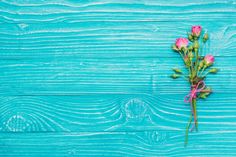 some pink flowers on a blue wooden surface