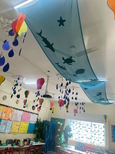 an empty classroom is decorated with colorful paper lanterns and fish decorations hanging from the ceiling