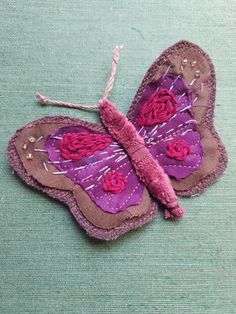 a purple butterfly with pink flowers on it's wings