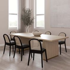 a dining room table with four chairs and a bowl of fruit on it