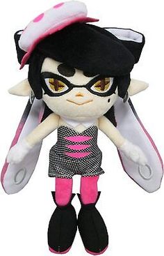 an image of a stuffed animal doll with big eyes and black hair wearing a dress