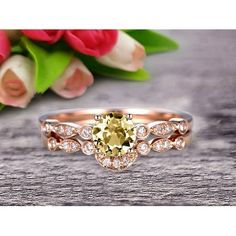 an oval shaped yellow diamond ring on top of a wooden table with flowers in the background