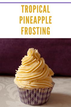 a cupcake sitting on top of a table with the words tropical pineapple frosting