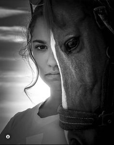 a black and white photo of a woman with a horse's head in the background