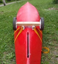 a red surfboard sitting in the grass