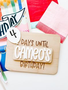 a wooden sign that says days until camoo's birthday on it next to other items