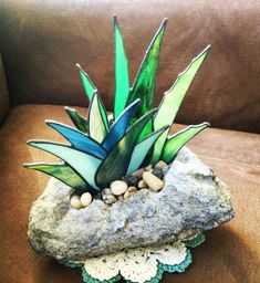 a glass plant sitting on top of a rock