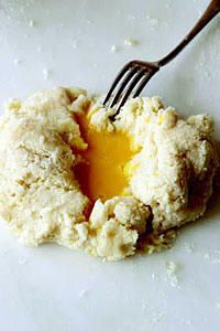 a fork is stuck into some food on a white plate with powdered sugar and butter