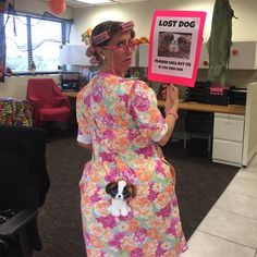 a woman holding up a sign with a dog on it