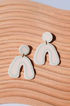 pair of white and blue earrings on wooden surface