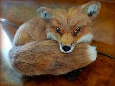 a close up of a stuffed animal on top of a wooden table with a blurry background