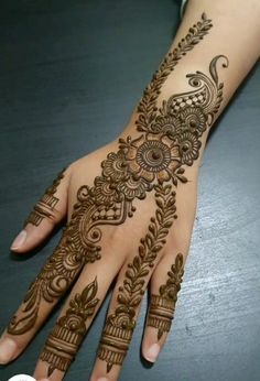 a woman's hand is decorated with hennap and floral designs on it