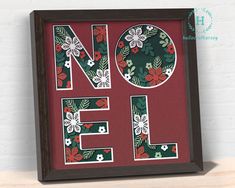 the word noel is made out of paper and decorated with red, green and white flowers