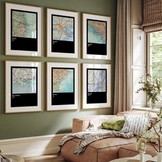 a living room filled with furniture and framed maps on the wall above it's windows