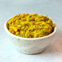 a white bowl filled with food on top of a table