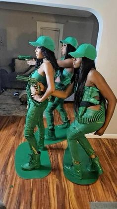 three women in green outfits standing on wooden floors