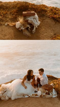 a couple sitting on top of a sandy beach next to the ocean in their wedding dresses