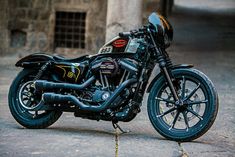 a black motorcycle parked on the street next to a building