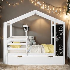 a child's bedroom with a white bed frame and yellow pillow cases on the bottom bunk